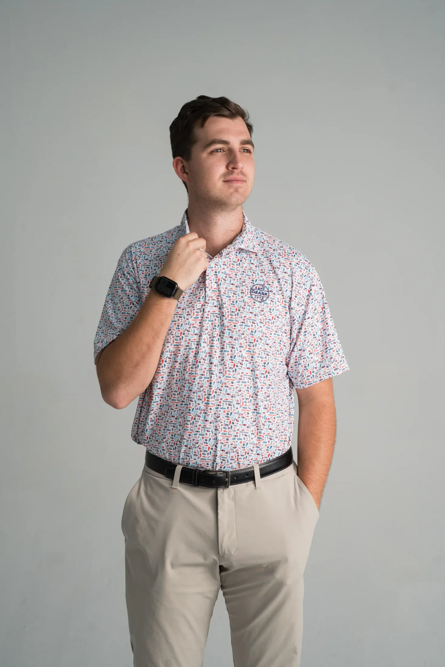 Model wearing a custom Camp Ozark polo with a colorful camp icon pattern
