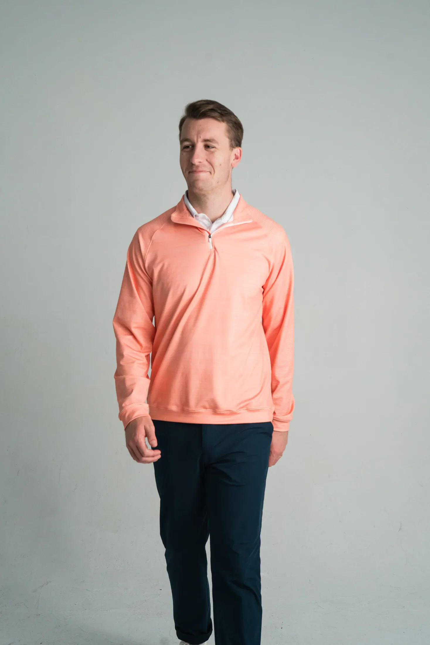 Model wearing a coral performance quarter zip