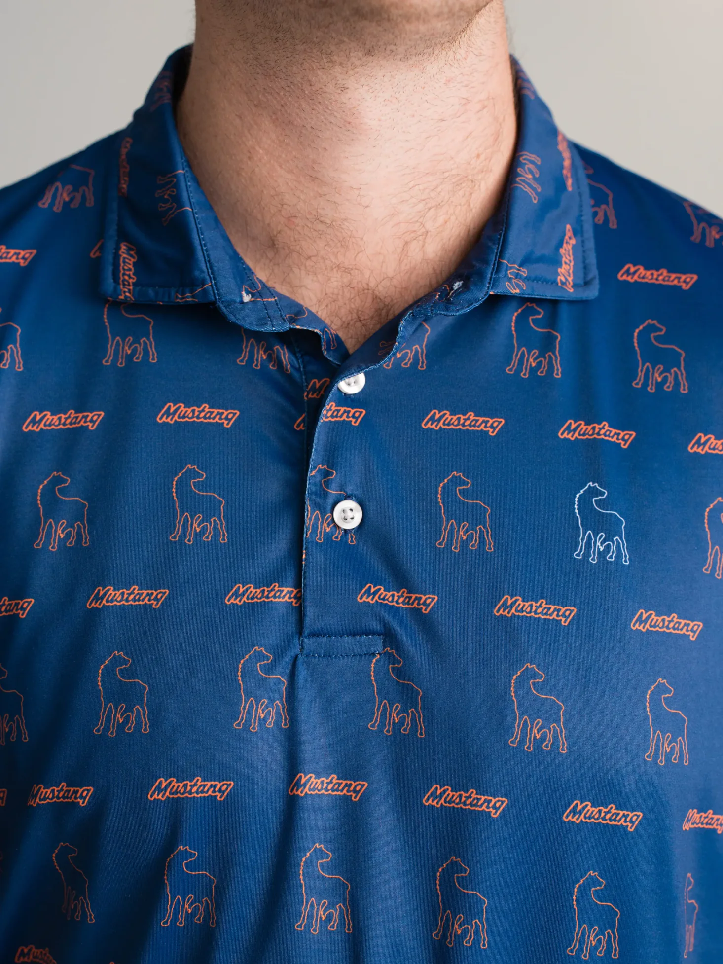 Navy Mustang Cat polo with repeating horse icons and embroidered branding