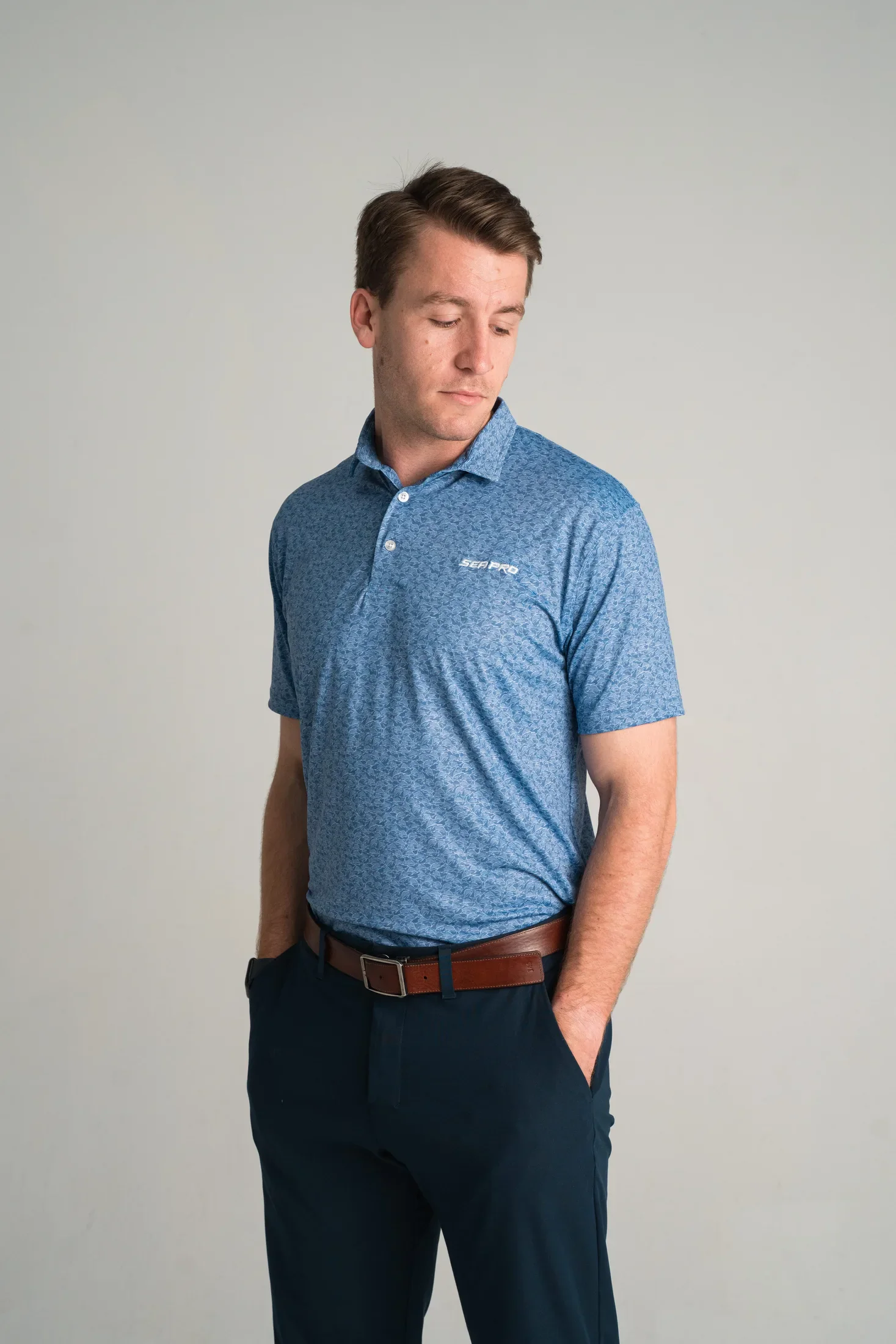Model wearing a blue Sea Pro polo with a marine micro print pattern