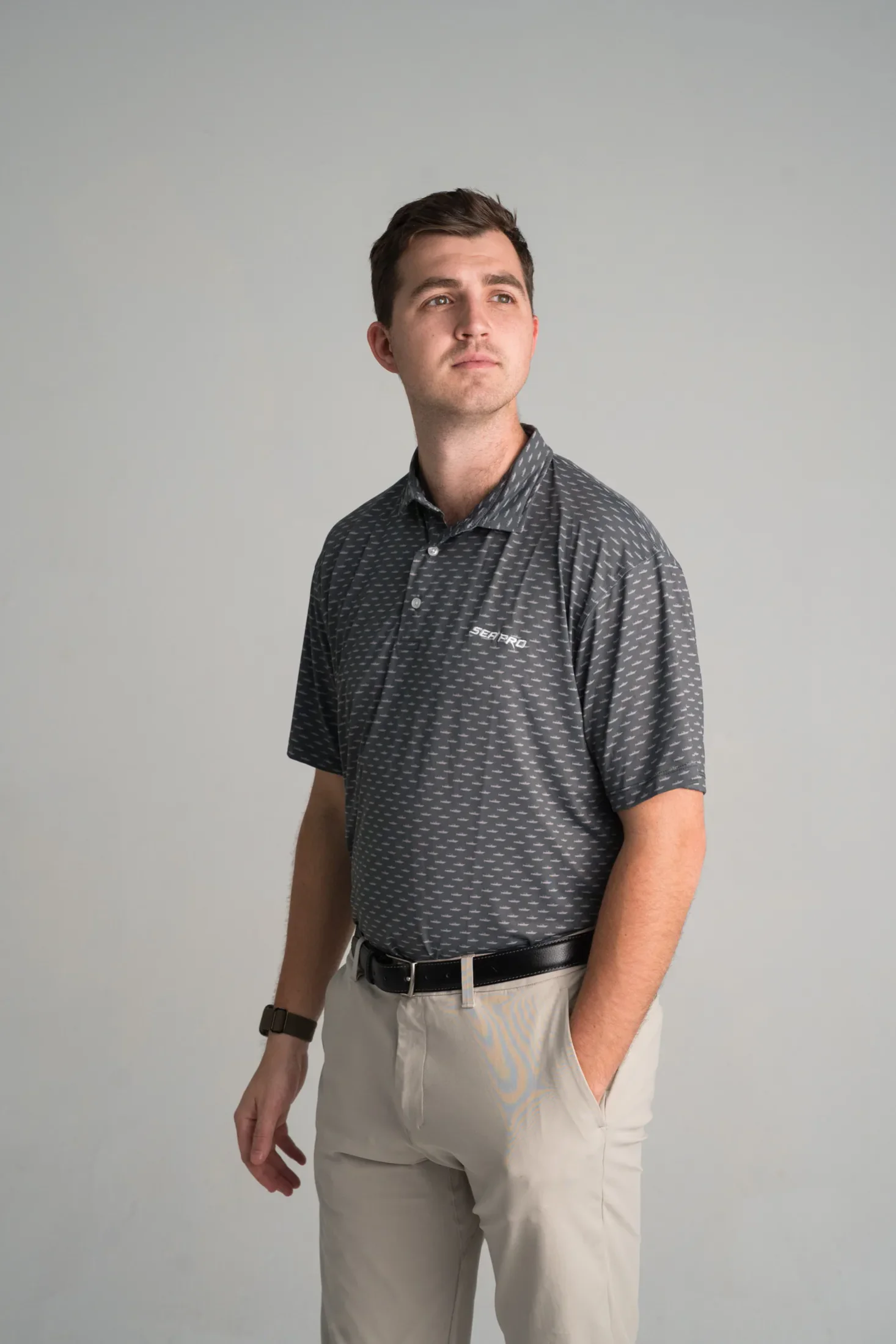 Model wearing a charcoal Sea Pro polo with a boat pattern