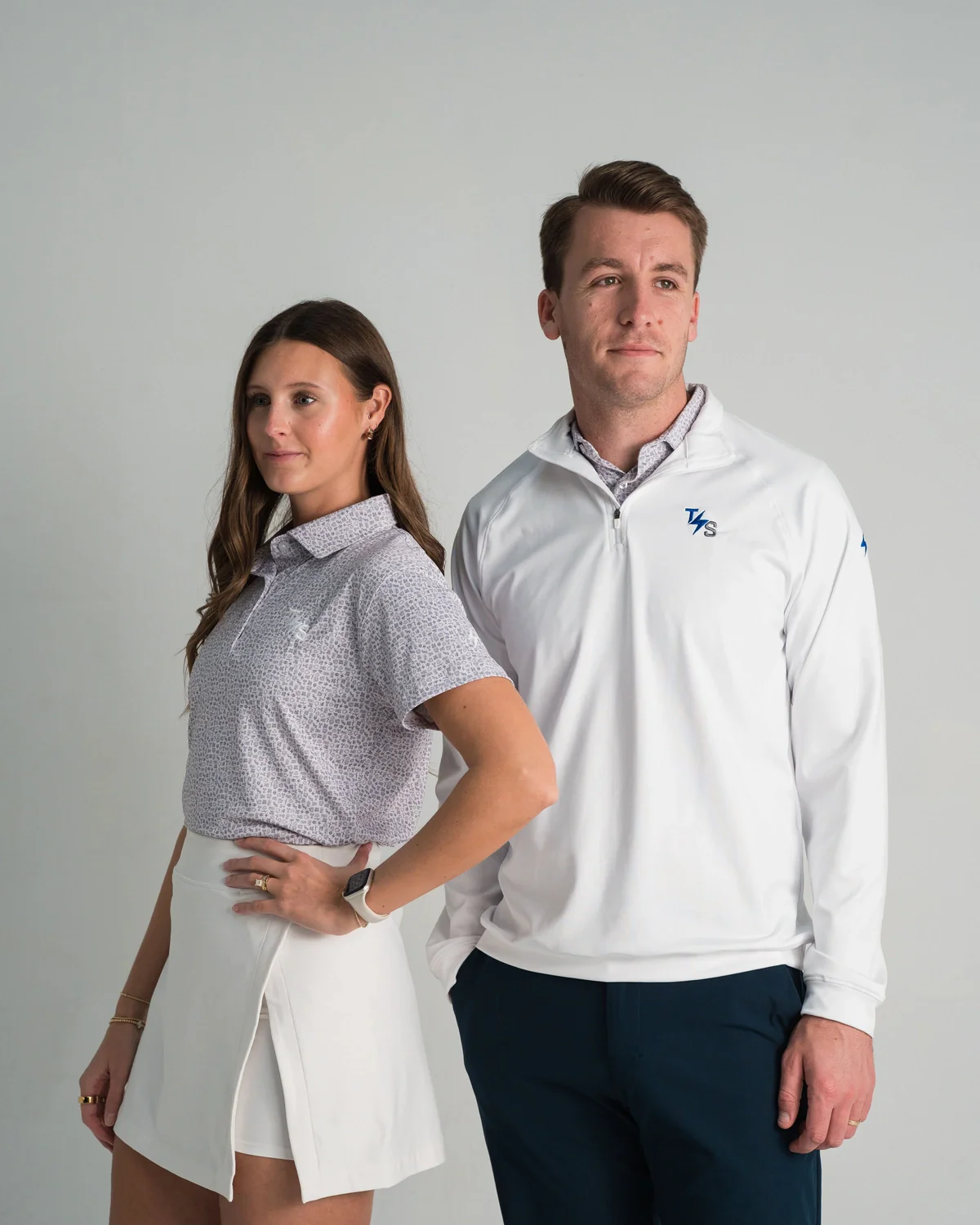 Woman in a TechServ micro print polo next to a man in a white TechServ quarter zip