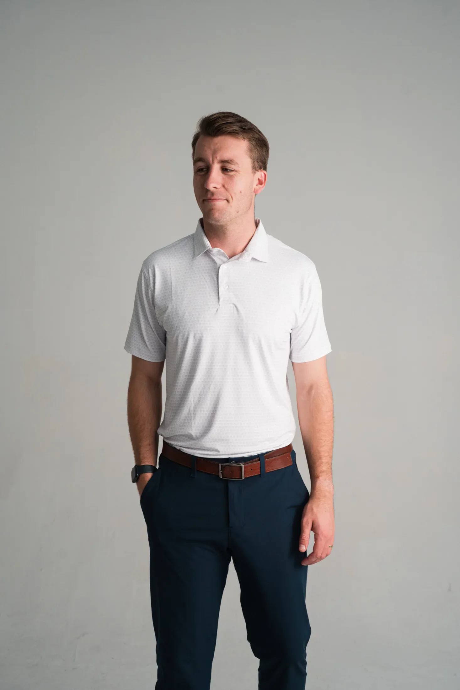 Model wearing a white polo with a subtle tonal micro print