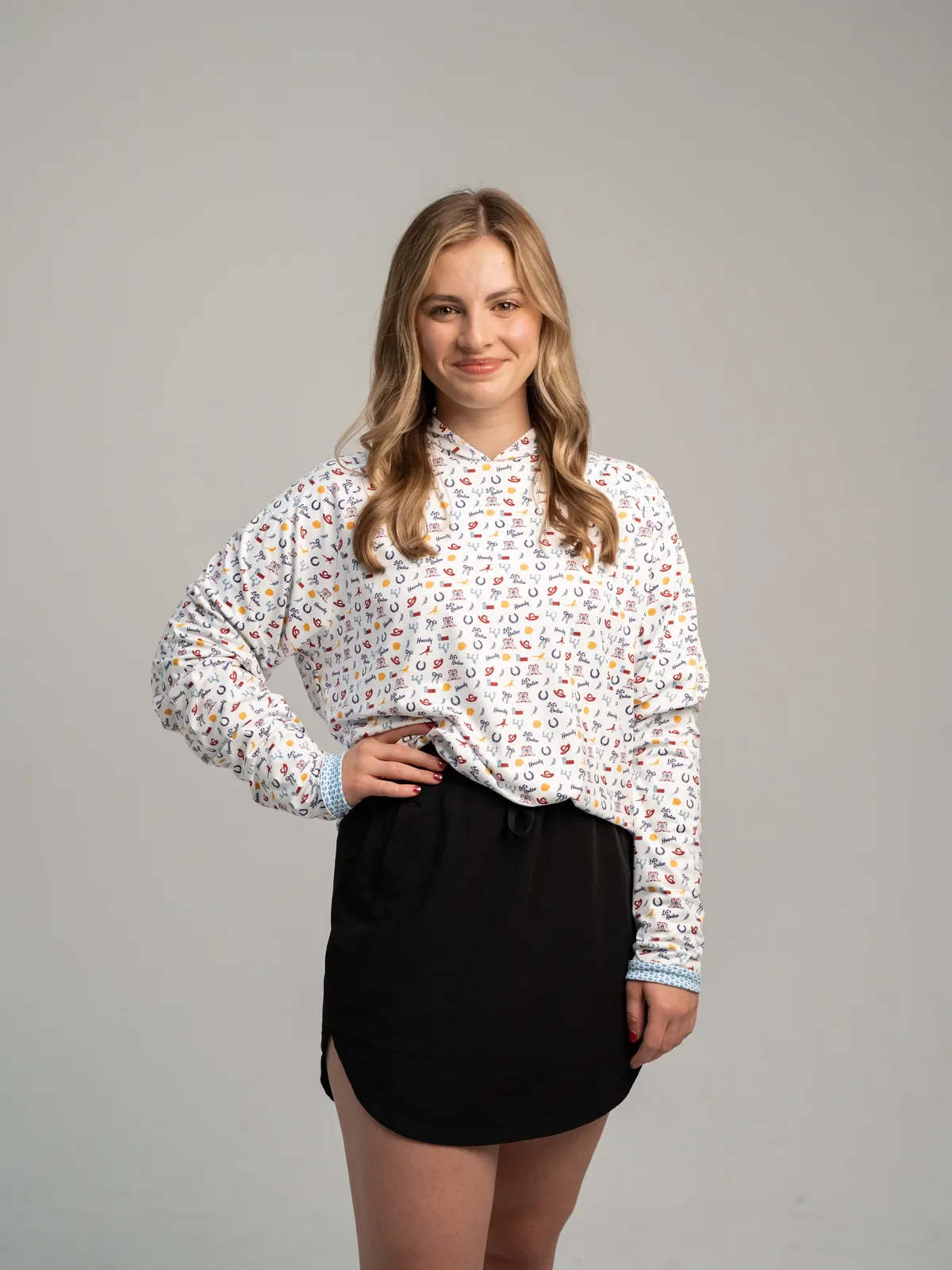 White women's hoodie with a colorful small icon pattern worn by a model