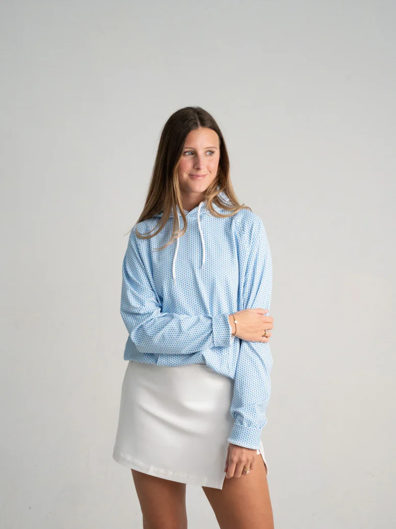 Woman wearing a light blue micro print hoodie and a white skirt