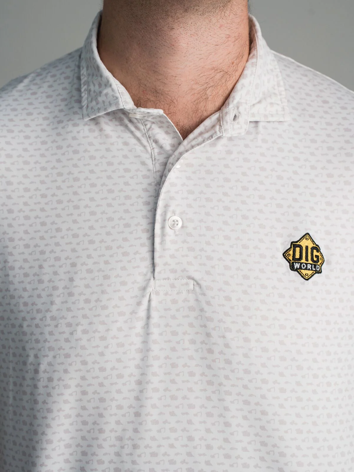 Custom polo with an equipment themed micro print and a Dig World patch