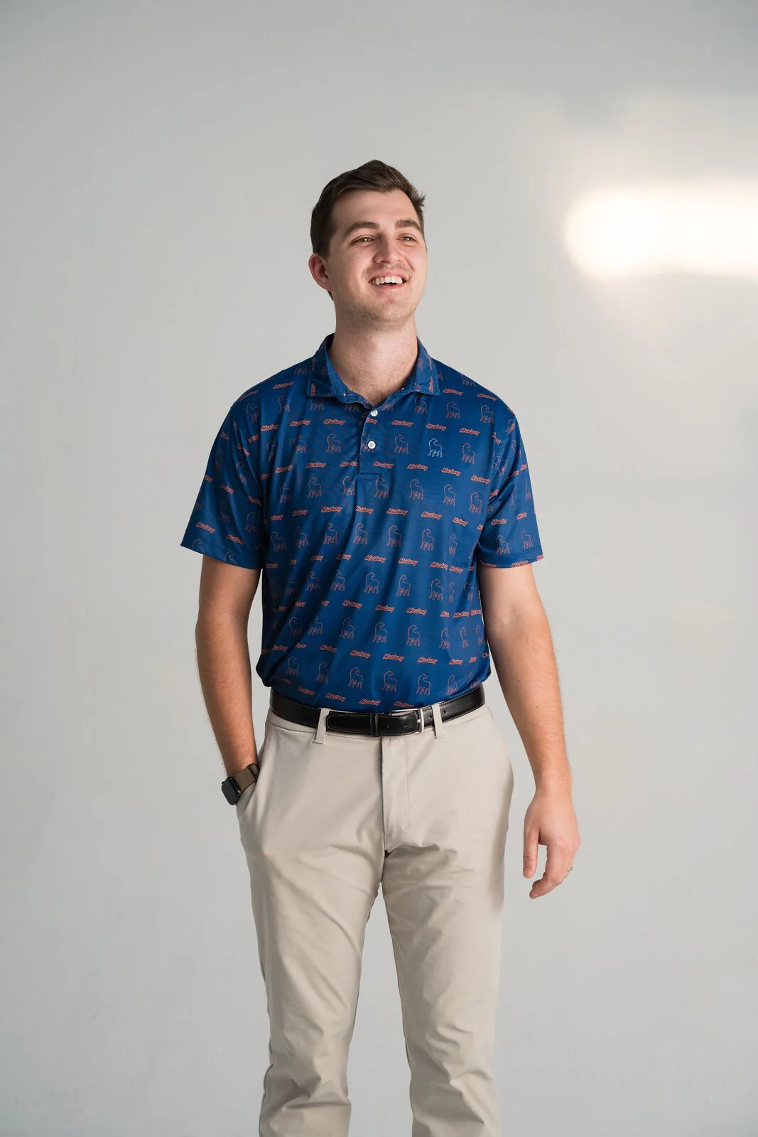 Man wearing a navy Mustang Cat polo with a two color print