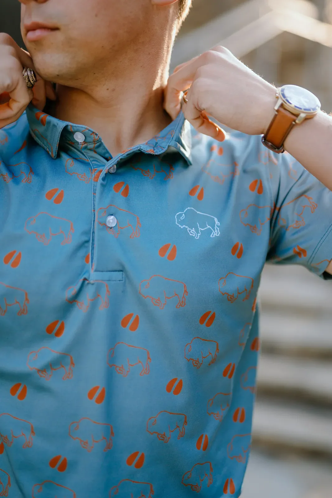 Close view of a blue custom polo with an orange bison pattern