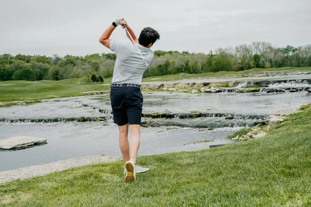 Custom golf shirt worn during a full golf swing