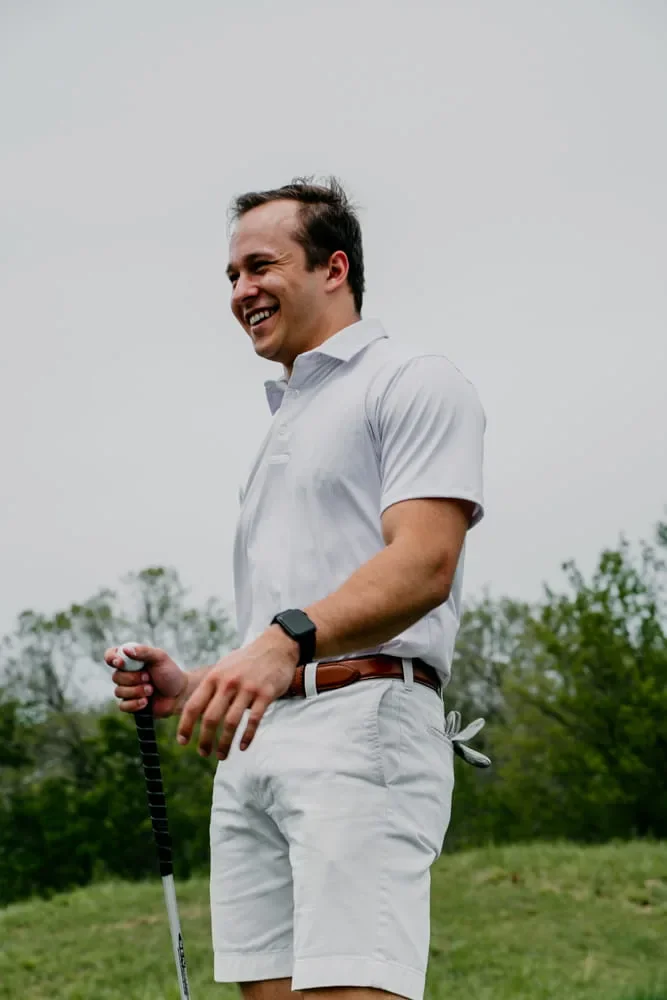 Custom golf polo worn by a golfer holding a club on the course