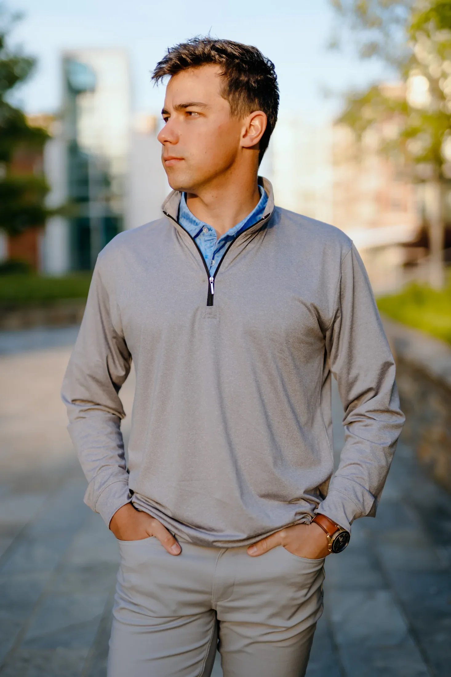 Gray quarter zip worn over a patterned polo for custom quarter zips